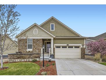 Charming home with a stone facade, a two-car garage, and a beautifully landscaped front yard at 15211 Quince St, Thornton, CO 80602