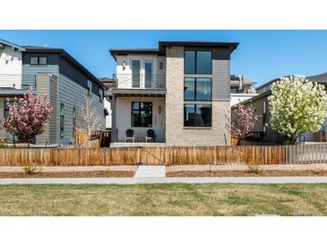 Charming two-story home with a stone facade, balcony, manicured lawn and inviting curb appeal at 6054 N Perth St, Aurora, CO 80019