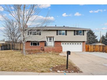 Ranch style home with brick and siding exterior, attached garage, and landscaped yard at 7636 S Eaton Way, Littleton, CO 80128