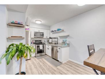 Well-lit kitchen features stainless steel appliances, gray granite countertops, and modern white cabinetry at 5300 E Cherry Creek South Dr # 804, Denver, CO 80246