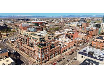Stunning aerial view of a modern brick building complex in a vibrant city with distant mountain views at 1499 Blake St # 3M, Denver, CO 80202