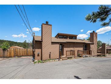 Two story home featuring a private entrance, chimney, and a spacious driveway for convenient parking at 30819 Hilltop Dr, Evergreen, CO 80439
