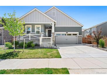 Charming home featuring a well-manicured lawn, gray two-car garage door, and inviting front porch at 872 S Flat Rock Way, Aurora, CO 80018