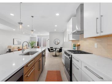 Bright, open kitchen with stainless steel appliances, white countertops, and a dining area at 3725 N Franklin St, Denver, CO 80205