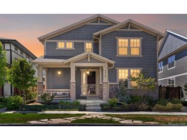 Charming two-story home with landscaped front yard, inviting porch, stone accents, and professionally maintained lawn at 5439 Verbena St, Denver, CO 80238