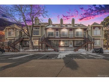 Attractive townhome featuring multiple levels and staircase access, with assigned parking spaces and winter dusk sky at 1885 S Quebec Way # C15, Denver, CO 80231