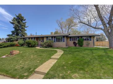 Charming ranch-style home featuring a well-maintained lawn and inviting walkway to the front door at 180 Dover St, Lakewood, CO 80226