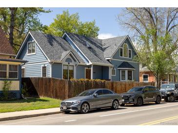 Charming two-story home with a well-manicured front yard and inviting curb appeal on a sunny day at 1605 17Th St, Boulder, CO 80302