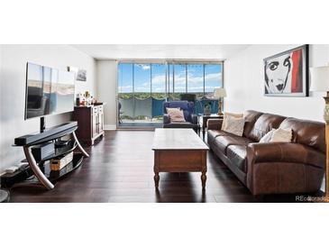 Bright living room featuring hardwood floors, a leather sofa and balcony with city views at 1155 N Ash St # 1408, Denver, CO 80220