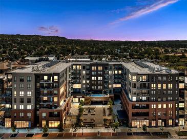 Stunning multi-story condominium building with mountain views at sunset and lush landscaping at 20 Wilcox St # 309, Castle Rock, CO 80104