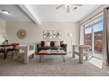 Stylish living room featuring modern decor and a sliding door to a private balcony at 7883 W 55Th Ave, Arvada, CO 80002