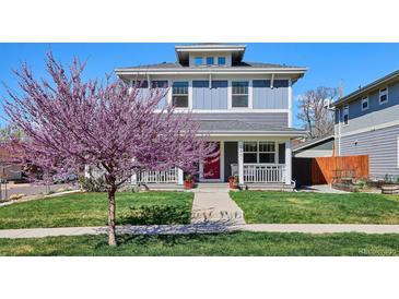 Charming two-story home featuring a welcoming front porch and a well-manicured lawn with a beautiful tree in bloom at 2801 Cherry St, Denver, CO 80207