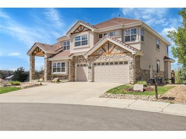 Beautiful two-story home featuring a stone facade and a spacious three car driveway at 23965 E Kettle Pl, Aurora, CO 80016