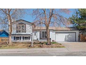 Charming home with a well-maintained front yard, white brick facade, and a two-car attached garage at 16543 E Kansas Pl, Aurora, CO 80017
