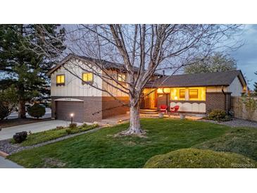 Charming two-story home with a well-manicured lawn and beautiful landscaping and an attached garage at 7290 Lamar Ct, Arvada, CO 80003