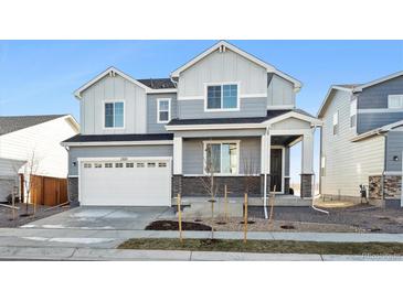 Two-story house with gray siding, white trim, and a two-car garage at 1322 Bloom St, Brighton, CO 80601