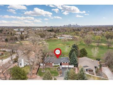 Expansive home with lush green lawn with the city skyline in the distance at 930 Reed Ct, Lakewood, CO 80214