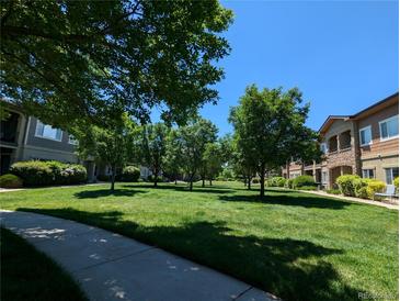 Lush, green community lawn lined with trees offers a park-like setting for residents at 1122 Olympia Ave # 12H, Longmont, CO 80504