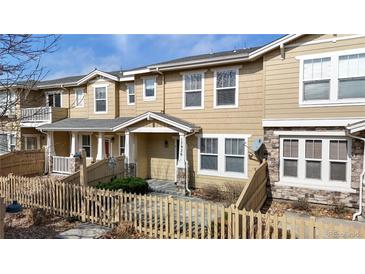 Inviting townhouse with a cozy front porch and well-maintained exterior, complemented by a charming picket fence at 17926 E 104Th Way # C, Commerce City, CO 80022