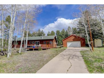 Charming cabin home with a spacious driveway and detached garage nestled in a forest setting at 26367 Pressler St, Conifer, CO 80433