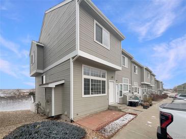 Inviting townhome with neutral siding, a well-kept lawn, and a driveway at 8199 Welby Rd # 1908, Denver, CO 80229