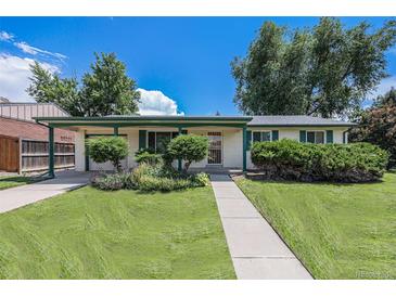 Charming single-story home with a well-manicured lawn, covered porch, and mature trees creating curb appeal at 5502 E Center Ave, Denver, CO 80246