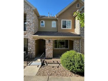 Charming townhome featuring a stone and siding exterior with well-maintained landscaping and inviting entryway at 11207 Osage Cir # B, Northglenn, CO 80234