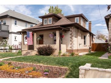 Charming brick home with a cozy front porch, a well-maintained lawn, and garden beds at 840 S Pennsylvania St, Denver, CO 80209