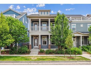 Charming two-story home boasts a cozy front porch, complemented by verdant landscaping and beautiful curb appeal at 11466 E 27Th Ave, Denver, CO 80238