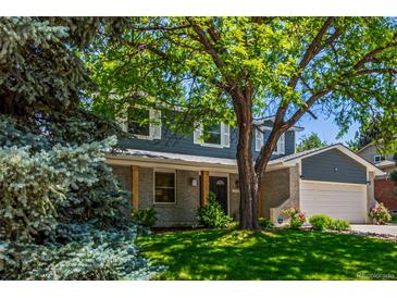 Charming two-story home with a manicured lawn and mature tree, offering a welcoming curb appeal at 5914 S Kearney St, Centennial, CO 80111