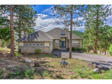 Charming home with stone accents, mature trees, and a welcoming entrance at 31042 Wildwoods, Evergreen, CO 80439