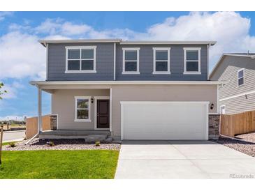 Charming two-story home with a two car garage, inviting entry and well manicured front lawn at 48255 Shetland Dr, Bennett, CO 80102