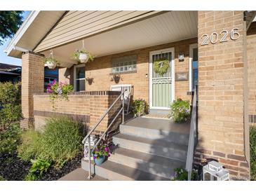 Inviting front porch with brick accents, decorative plants and room for seating at 2026 S Lincoln St, Denver, CO 80210