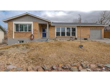 Brick ranch home with attached garage and landscaped yard at 5456 Eagle St, Denver, CO 80239