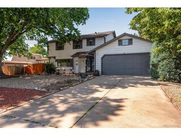 Charming two-story home featuring a two-car garage, landscaped front yard, and a welcoming entrance at 10851 E Iliff Pl, Aurora, CO 80014