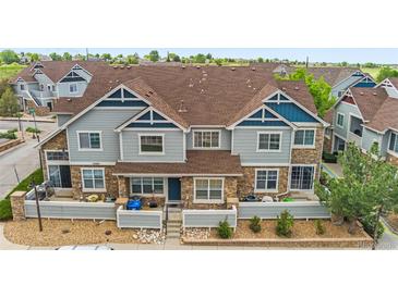 Attractive townhome featuring stone accents, light blue siding, and a neatly landscaped front yard at 23465 E Platte Dr # B, Aurora, CO 80016