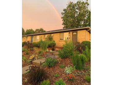 Charming home with a lush, landscaped front yard and a rainbow in the sky at 4332 Bruce Randolph Ave, Denver, CO 80207