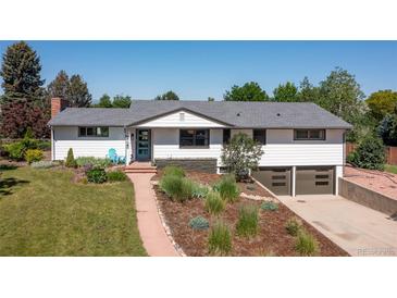 Charming ranch-style home with a landscaped front yard, a blue front door, and a two-car garage at 2125 Rangeview Ln, Longmont, CO 80501