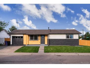 Charming single-story home featuring a combination of wood and brick exterior, complemented by a well-manicured lawn at 5304 Granby St, Denver, CO 80239
