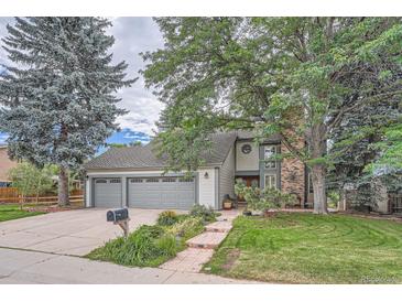 Charming two-story home featuring a three-car garage and a beautifully landscaped front yard with mature trees at 8216 S Krameria Way, Centennial, CO 80112
