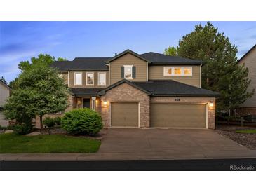 Charming two-story home boasts a two-car garage, manicured lawn, and brick accents at 10524 Serengeti Dr, Lone Tree, CO 80124