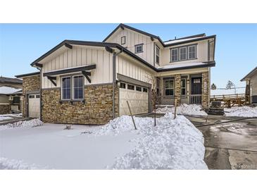 Beautiful two-story home featuring stone accents, a front porch, and an attached two-car garage at 17402 W 93Rd Pl, Arvada, CO 80007
