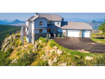 Stunning hillside home with stone accents, three car garage, and mountain views at 14440 Eagle Vista Dr, Littleton, CO 80127