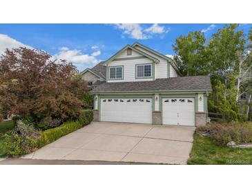 Charming two-story home featuring a three-car garage, lush landscaping, and a welcoming facade at 248 Summit Trl, Broomfield, CO 80020