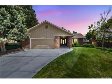 Charming exterior of a home with a lush green lawn and a driveway leading to an attached garage at sunset at 37 E 14Th Pl, Broomfield, CO 80020