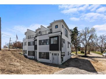 Modern townhome featuring a black and white exterior, balconies, and a contemporary design at 2253 Kipling St, Lakewood, CO 80215