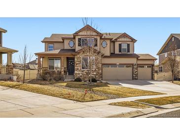 Charming two-story home with stone accents, well-maintained lawn, and three-car garage at 8768 Foxfire St, Firestone, CO 80504