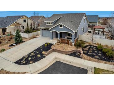 Charming home featuring a well-manicured lawn, complemented by landscaped garden beds and a spacious driveway at 5519 Genoa St, Denver, CO 80249