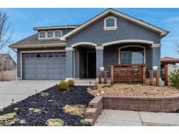 Charming single-Gathering home featuring a stucco exterior and well-maintained front yard with decorative stonework at 5519 Genoa St, Denver, CO 80249
