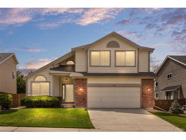 Charming two-story home with a well-manicured lawn and a brick-accented facade at 8985 Edgewood Ln, Highlands Ranch, CO 80130
